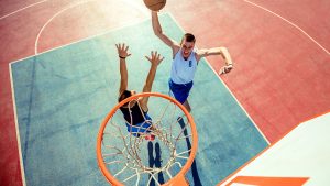 Basketball game, with someone scoring a slam dunk