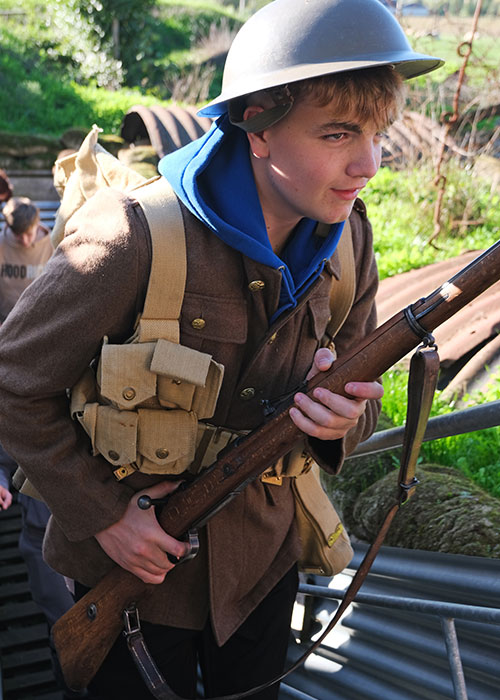Student dresses in WW1 clothing and carries a rifle 