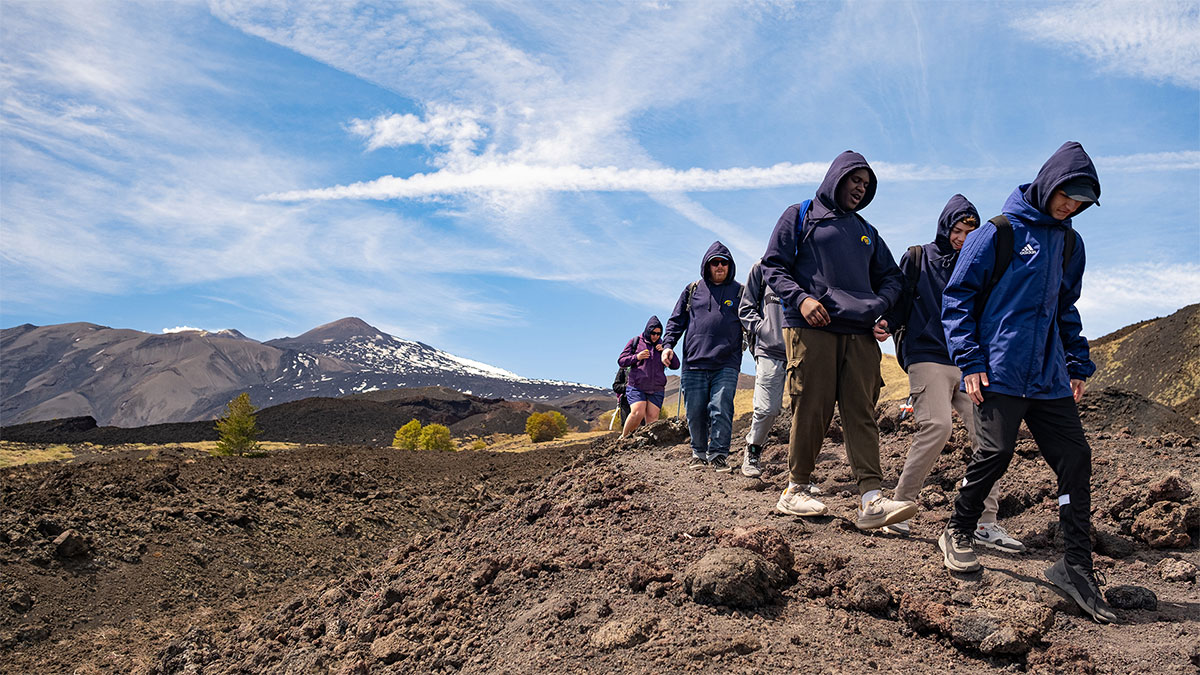 Students trekking in Sicily with a mountain landscape