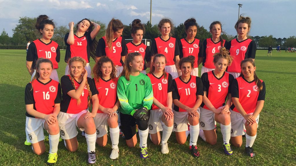 Group shot of a girls football team wearing a red kit