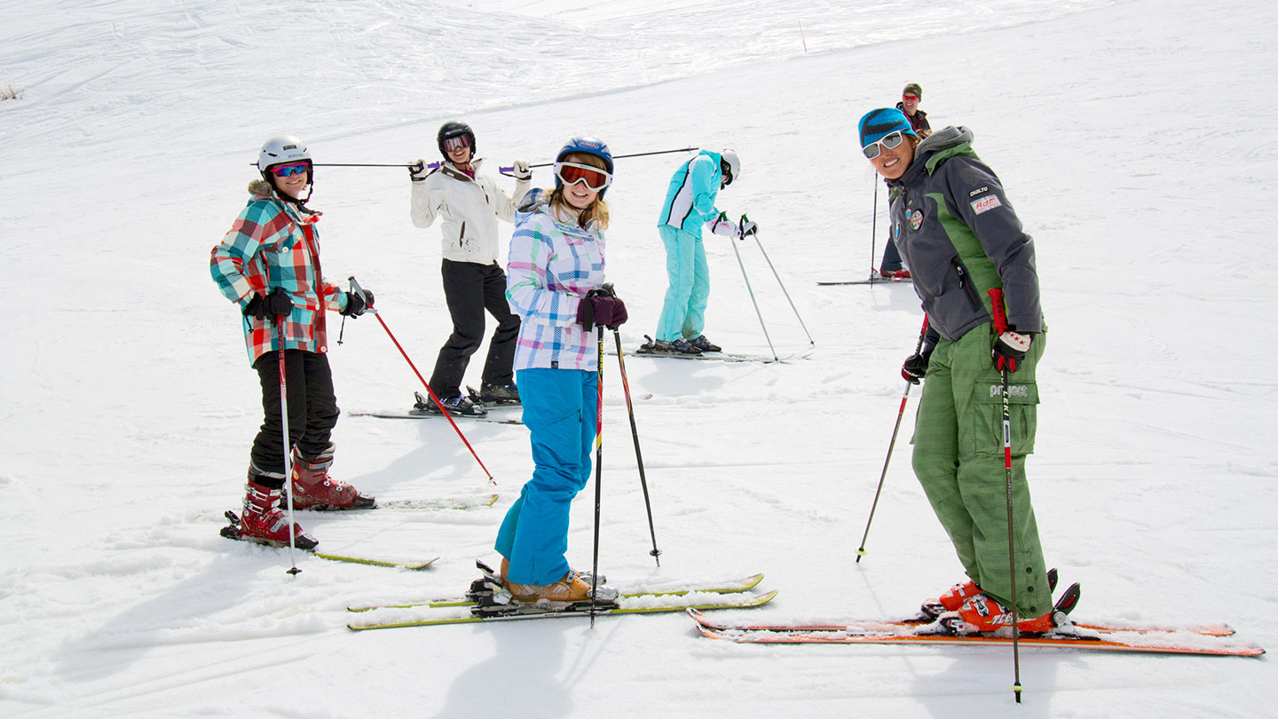 Skiers and instructor heading down the slopes