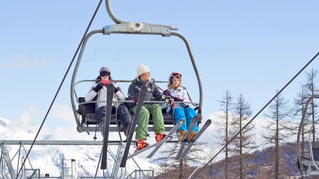 Three skiers enjoying a leisurely ride on a ski lift