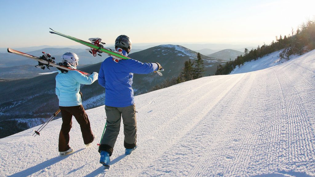 Two skiiers walking with skis on their shoulder at Sugarloaf