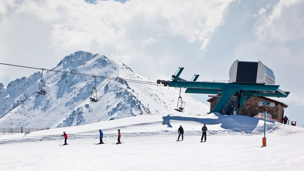 Skiers starting their run after catching a lift on the slopes of Vallnord, Andorra