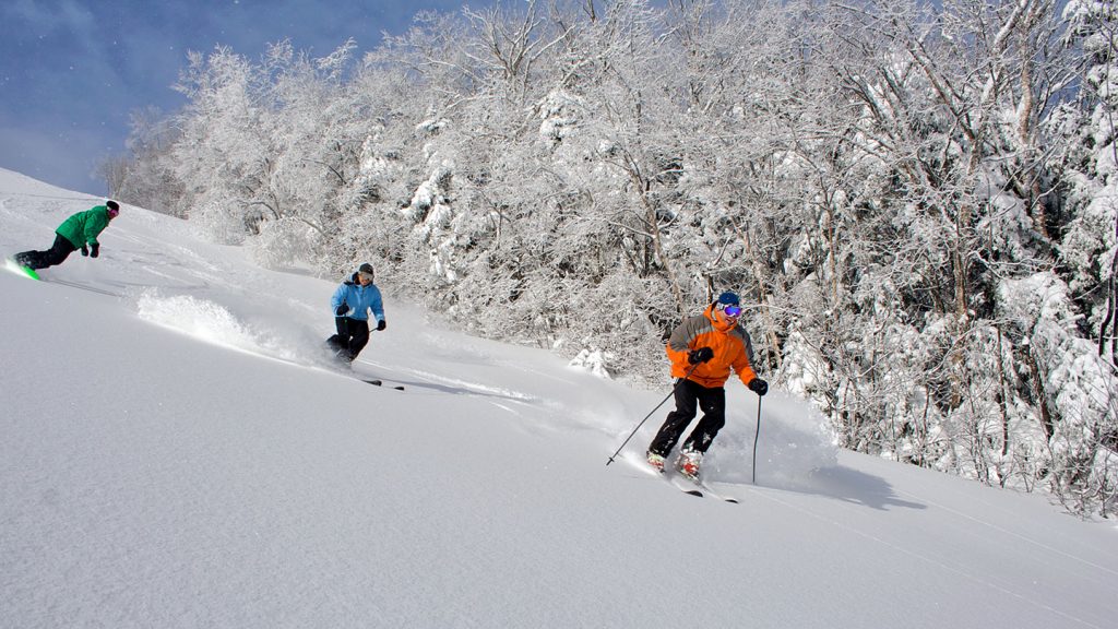 Two skiers heading down slope at Waterville Valley USA