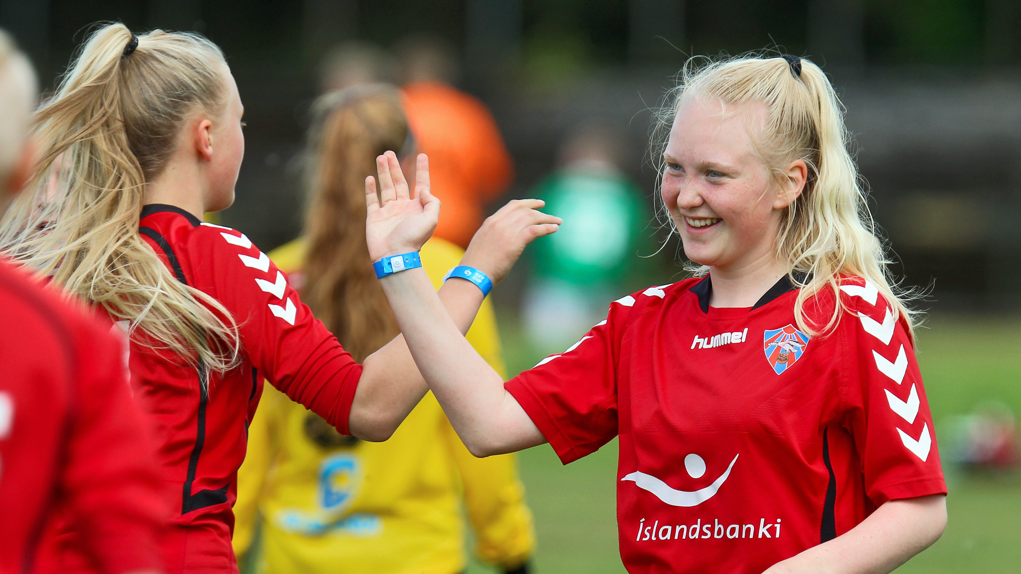 Girl footballers high-five each other.