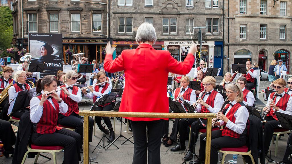 An adult concert band performing on the street