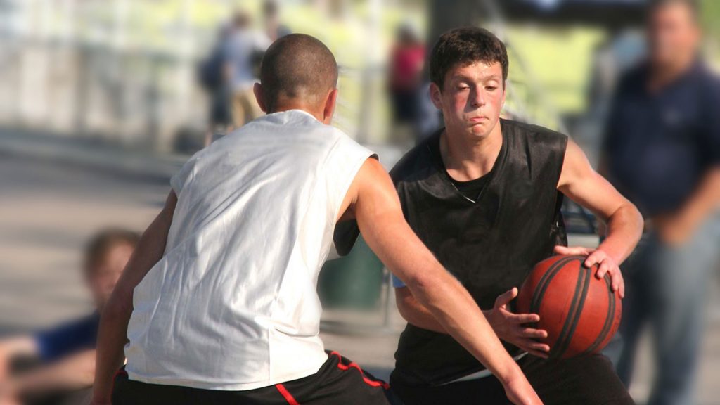 Two basketball players compete for the ball.