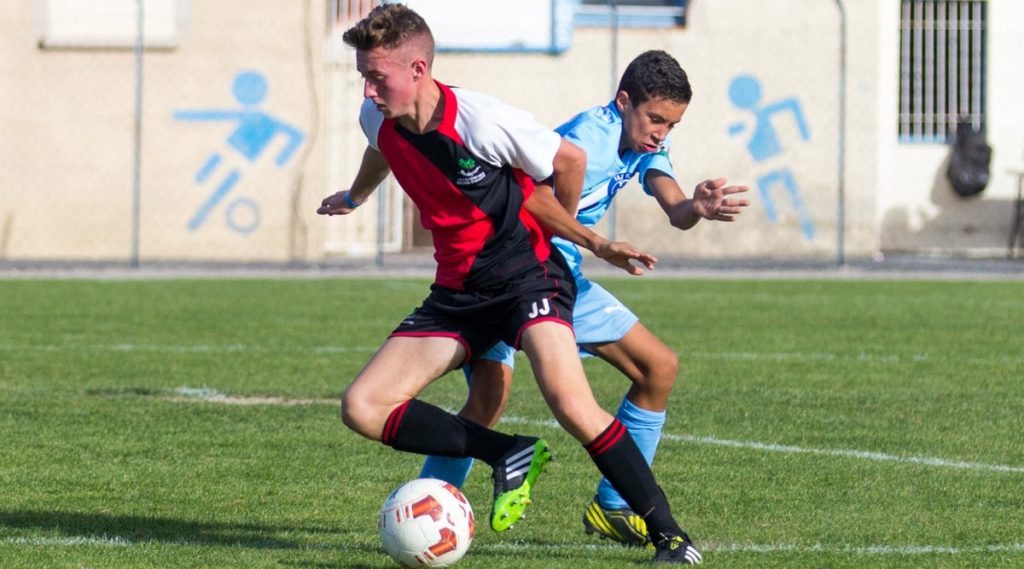 Two footballers compete for the ball