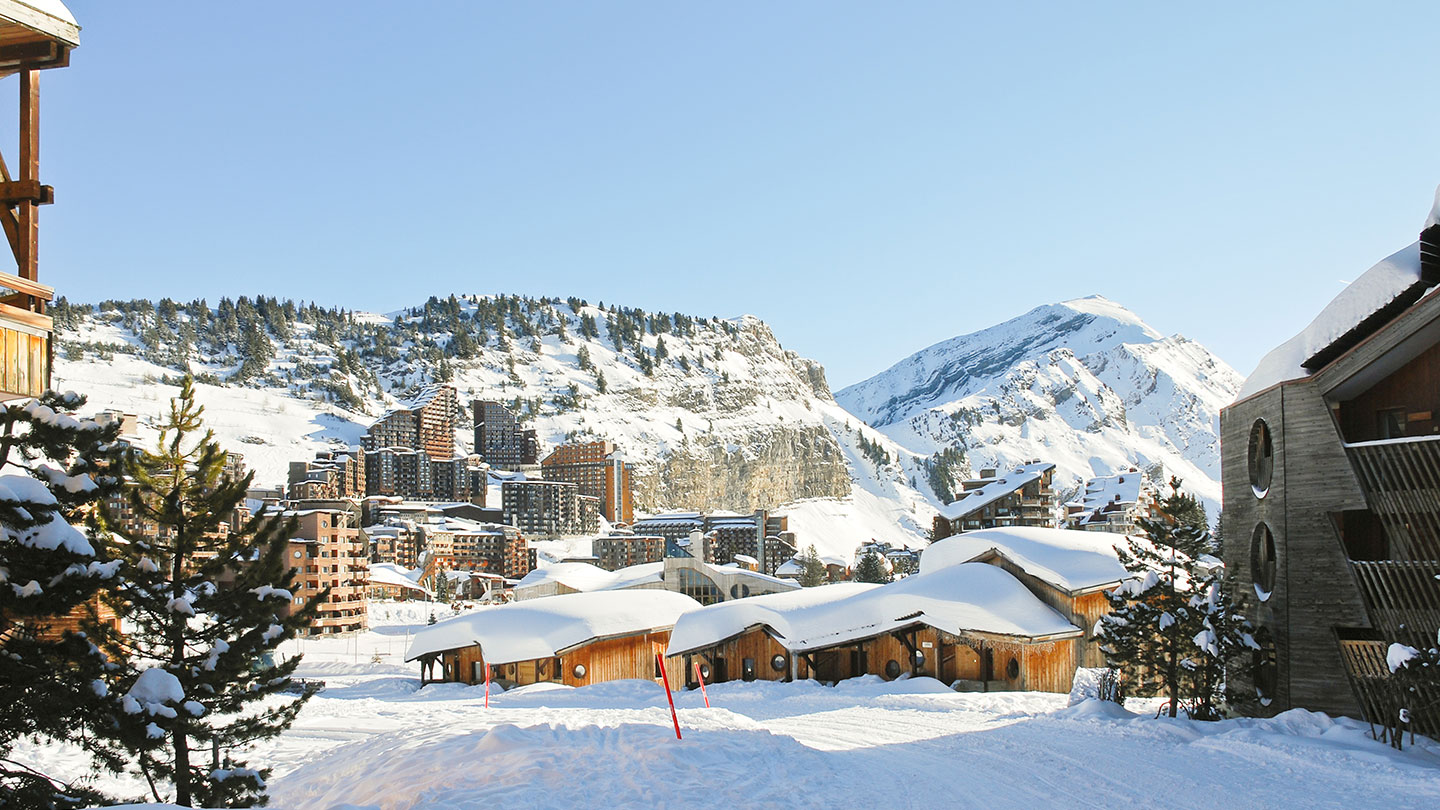 Snow-covered Morzine, with rustic wooden chalets, trees and mountains