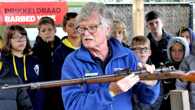 History Tour Guide - Trevor, educating students on an old WW1 rifle