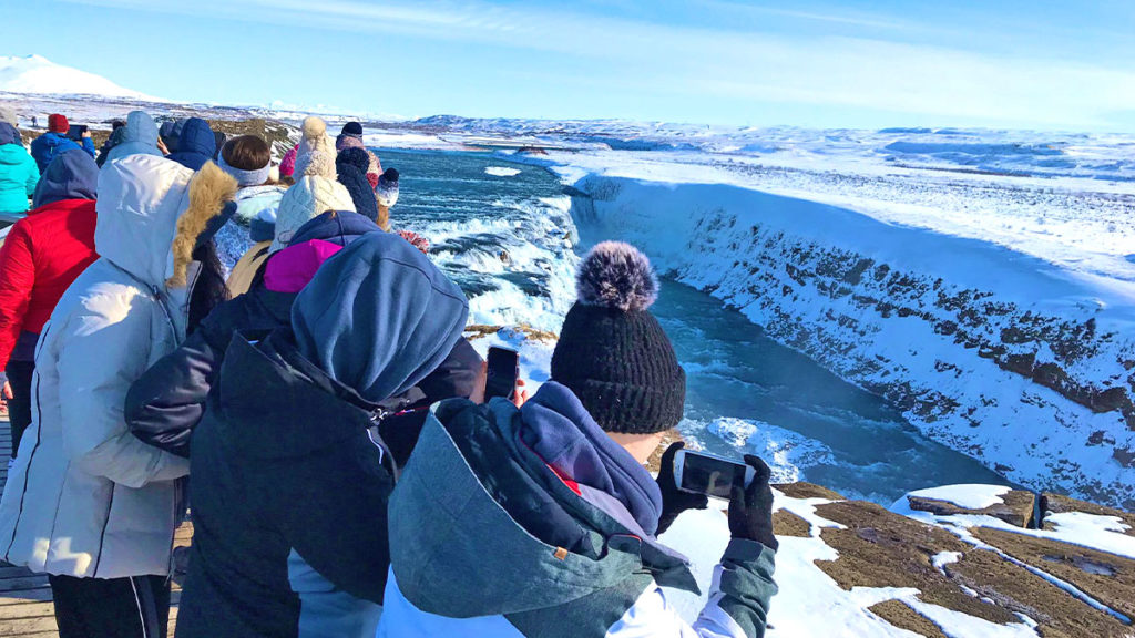 Students taking photo's of scenery on a geography school trip to Iceland