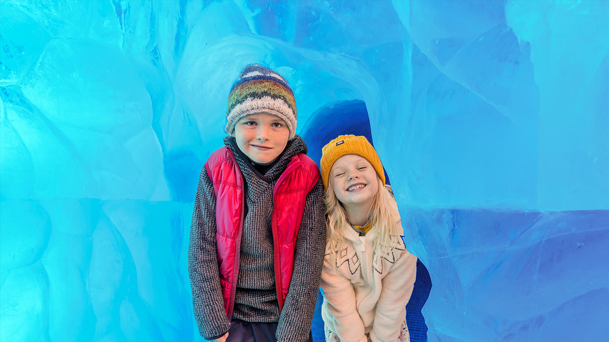 Young girl and boy walking through the ice tunnel at Perlan, Iceland