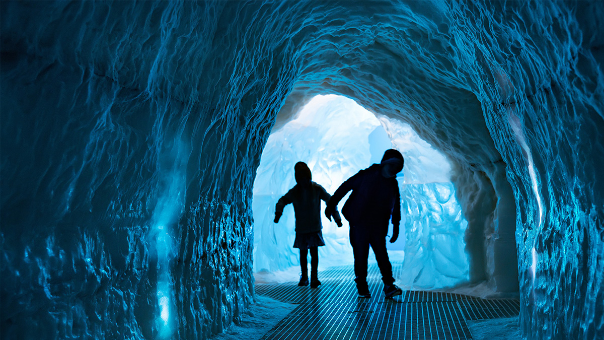 Young children exploring the ice tunnel at Perlan, Iceland