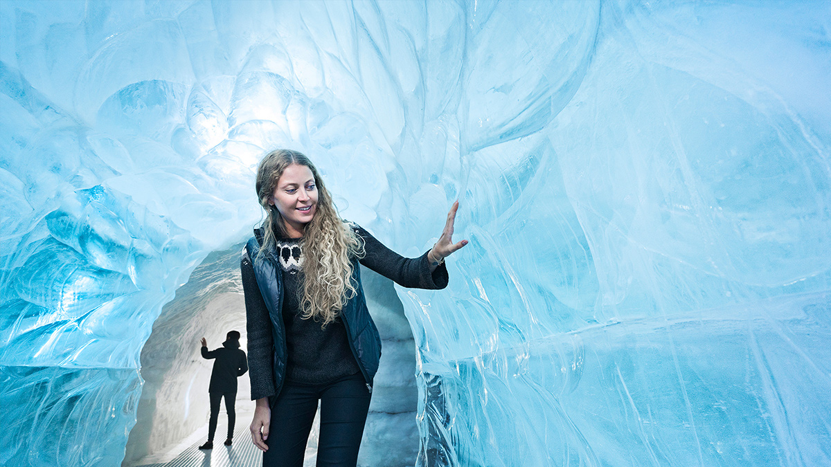 Young woman exploring the ice tunnel at Perlan, Iceland