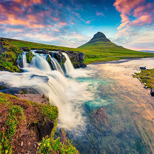 Summer sunset on famous Kirkjufellsfoss Waterfall and Kirkjufell mountain