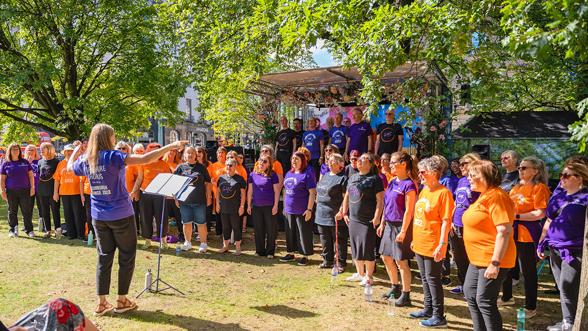 10 Best Ways on How To Prepare for Your Music Tour: a choir perform outside in the sun with their choral director at the front