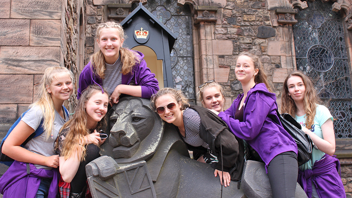 9 top tips on how to plan the perfect school concert tour: A group of students posing on a statue on a school concert tour