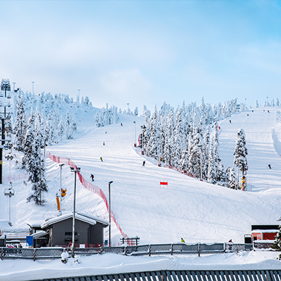 Multiple ski slopes meet at the bottom of a snowy hill