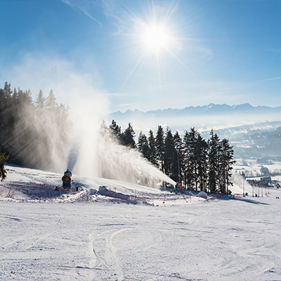 Snow cannons coating a ski slope with fresh snow