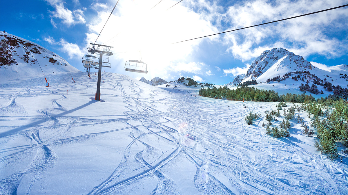 snowy hills with ski slopes and ski lifts above
