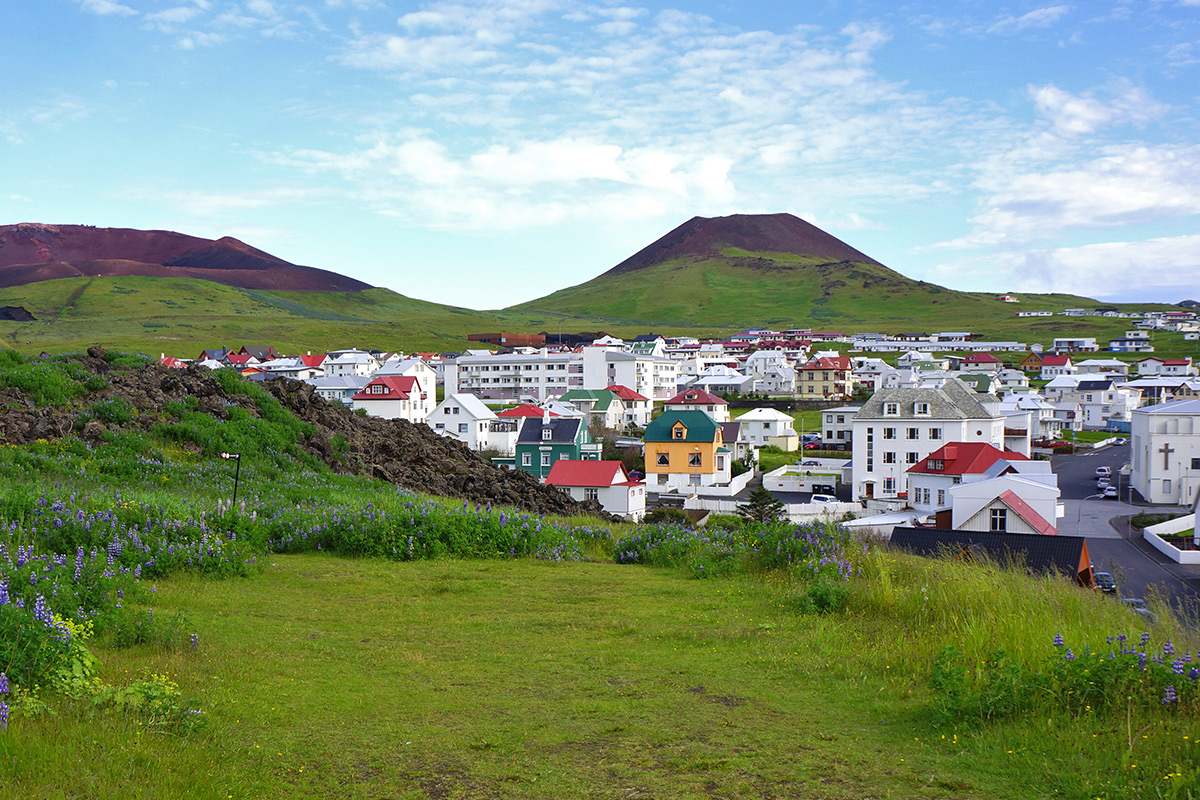 A view of Eldfell Volcano behind a small Icelandic Town
