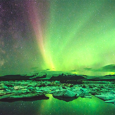 The Northern Lights visible over a beautiful landscape in Iceland