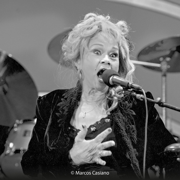 Photography of Etta James singing on a stage with a band, copyright: Marcos Casiano