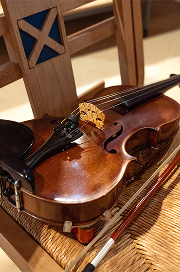 A violin resting on a chair in a hall in Edinburgh, UK