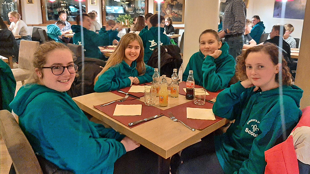 4 young students waiting for pizza to arrive in a restaurant in Tarvisio, Italy in the February half-term ski season 2023