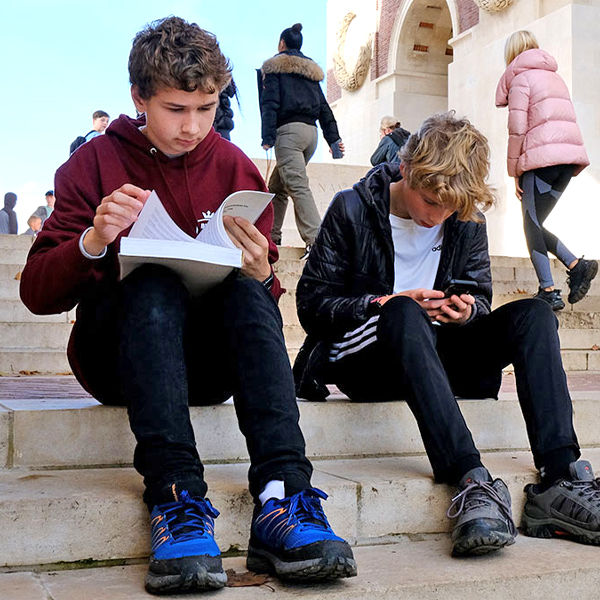 Two students work together on the steps of Menin Gate in 4 Reasons and 4 Affordable Tips for Your School Tour 