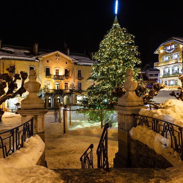 A Christmas Tree in a snow covered village centre.