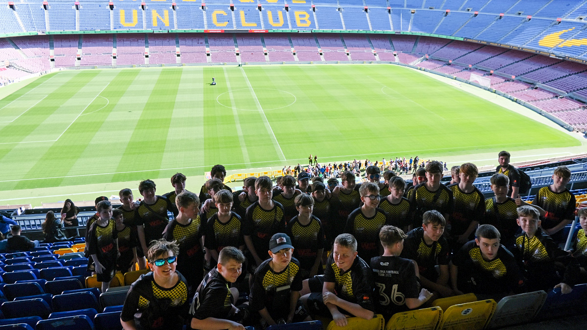 a Barcelona School Football Tour poses in the stands of the Nou Camp