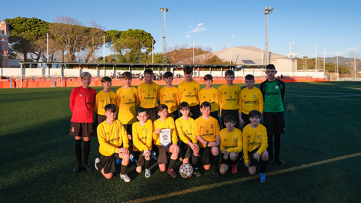 a UK school poses on the Spanish pitch before their match against a local side on their Barcelona School Football Tour