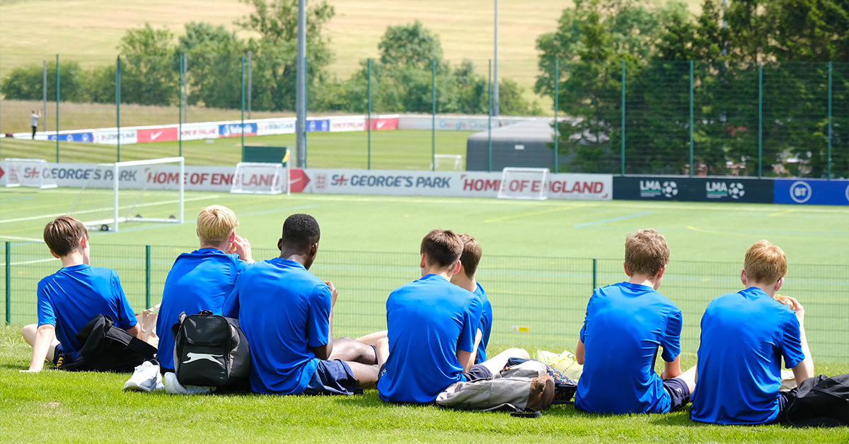 Young Football players sitting and eating lunch at St Georges Park, during pro coaching