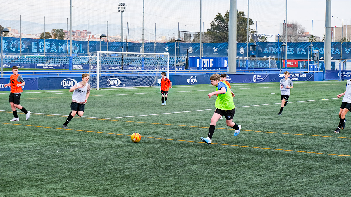 Students compete for a passed ball on an hired pitch at RCD Espanyol on a Barcelona School Football Tour