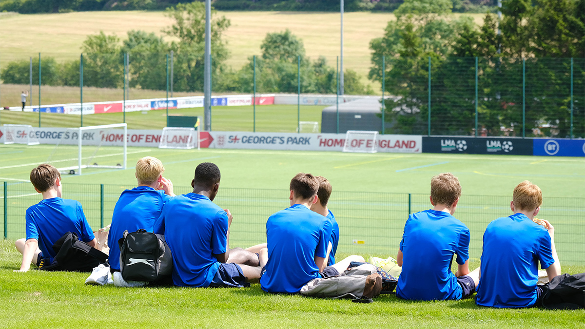 Young Football players sitting and eating lunch at St Georges Park, during pro coaching