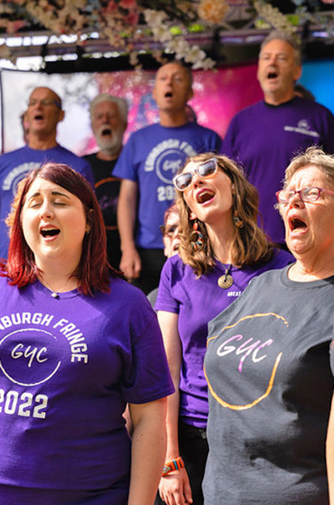 Adult Choristers sing outside in the sun at the Edinburgh Fringe on their concert tour