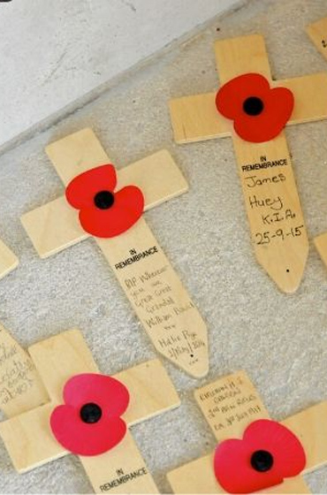 Wooden crosses with a poppy lain on a carpet in the Explore History Hub