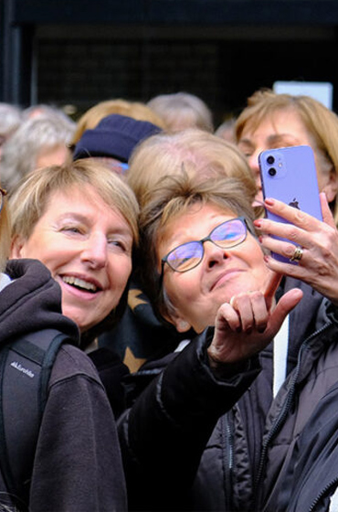 Two female adult concert tour goers take a selfi