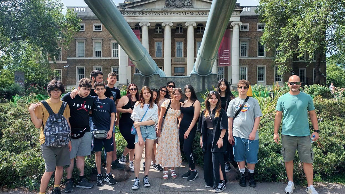 Grammar School Nicosia students and a teacher pose outside, on a sunny day, in front of the Imperial War Museum in London.