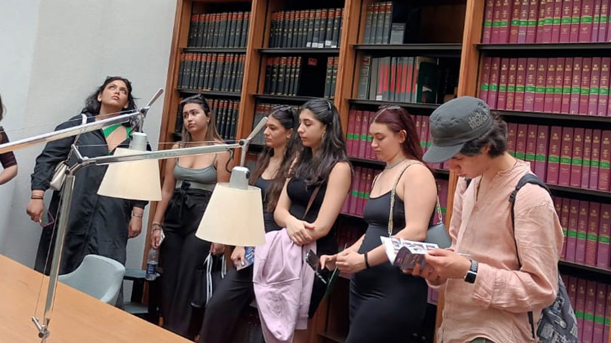 Students listen, read and look around a conference room in the Supreme Court in London.