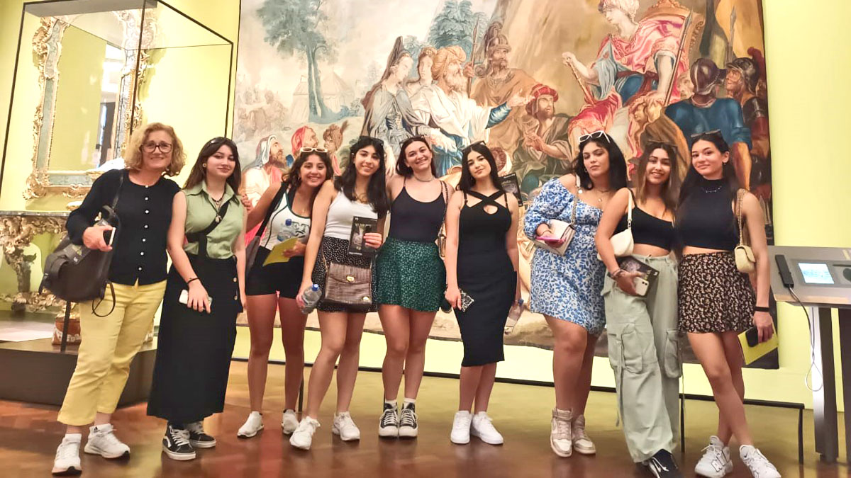Students from the Grammar School Nicosia pose in front of a painting and an exhibit at a museum
