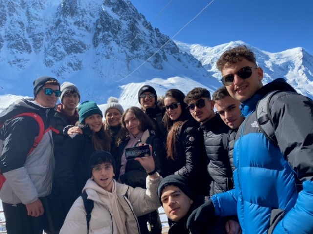 Students from Grammar School Nicosia taking a group selfie with Swiss mountains behind them.