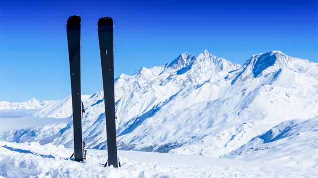 Ski's in some snow with a blue skies mountain landscape