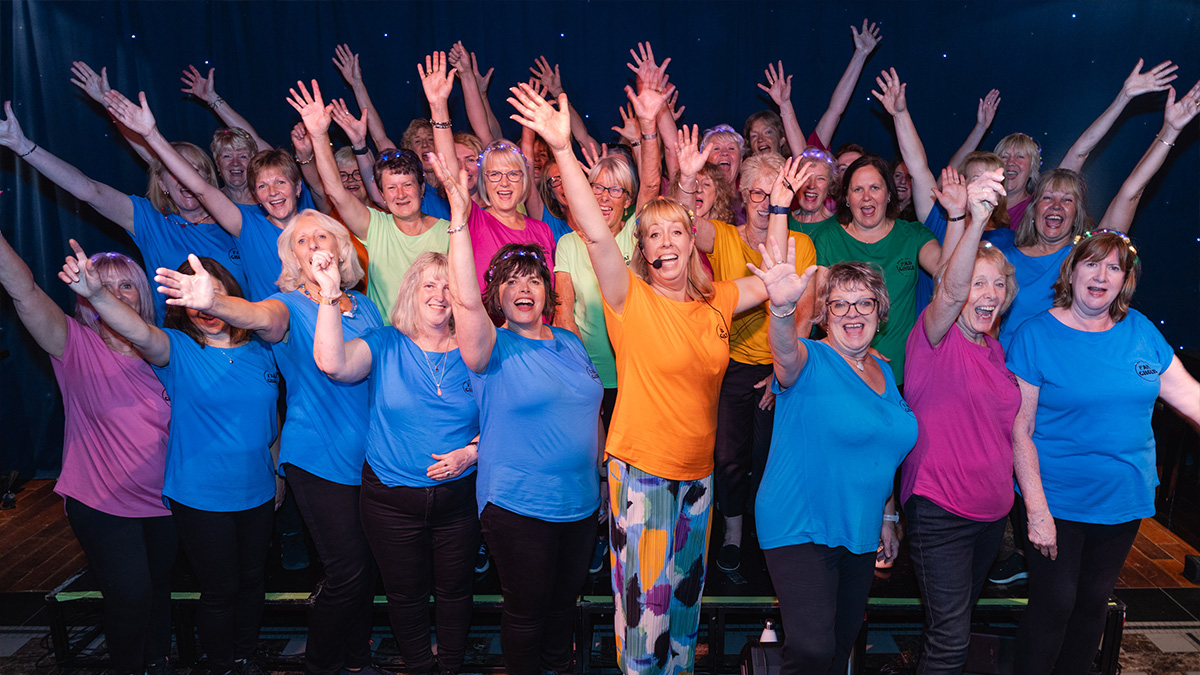 Fab Choir pose with hands high at Le Monde at the Edinburgh Fringe Festival.