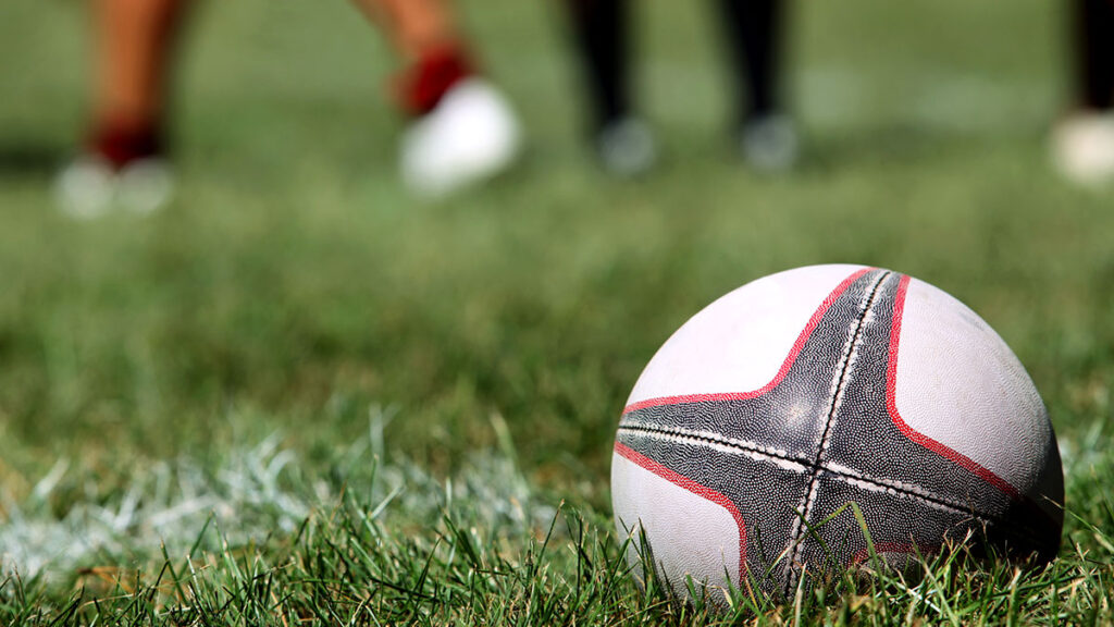 Rugby Ball placed on a pitch in the corner.