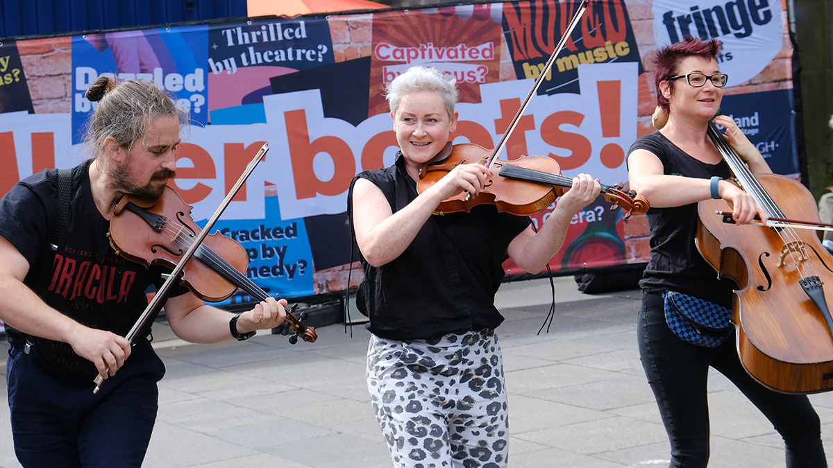 Two violinists and a cellist play in the street at Edinburgh Fringe 2023