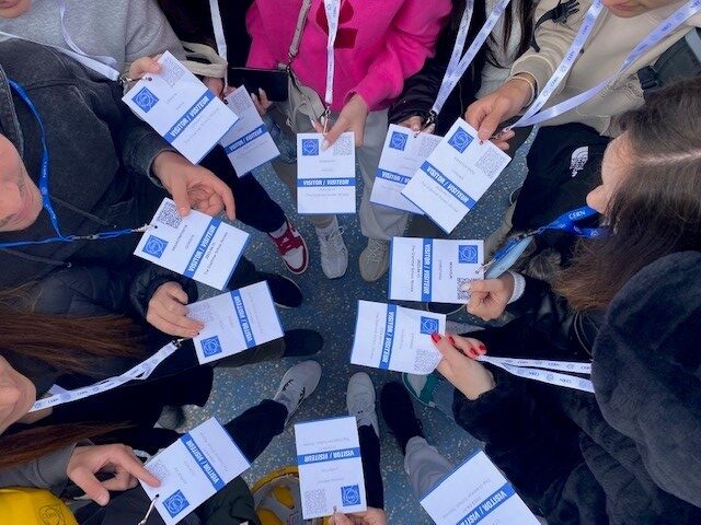 Students take a top down picture of their CERN passes lined in a circle