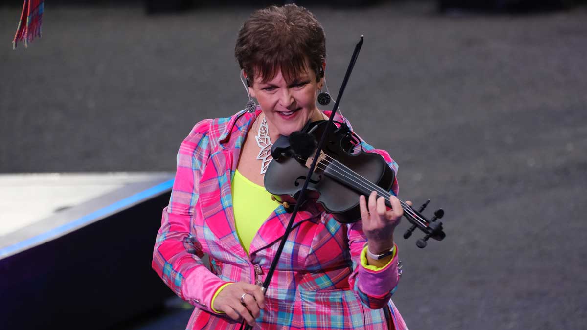 A violinist wearing a pink neon suit performs at the Edinburgh Tattoo.